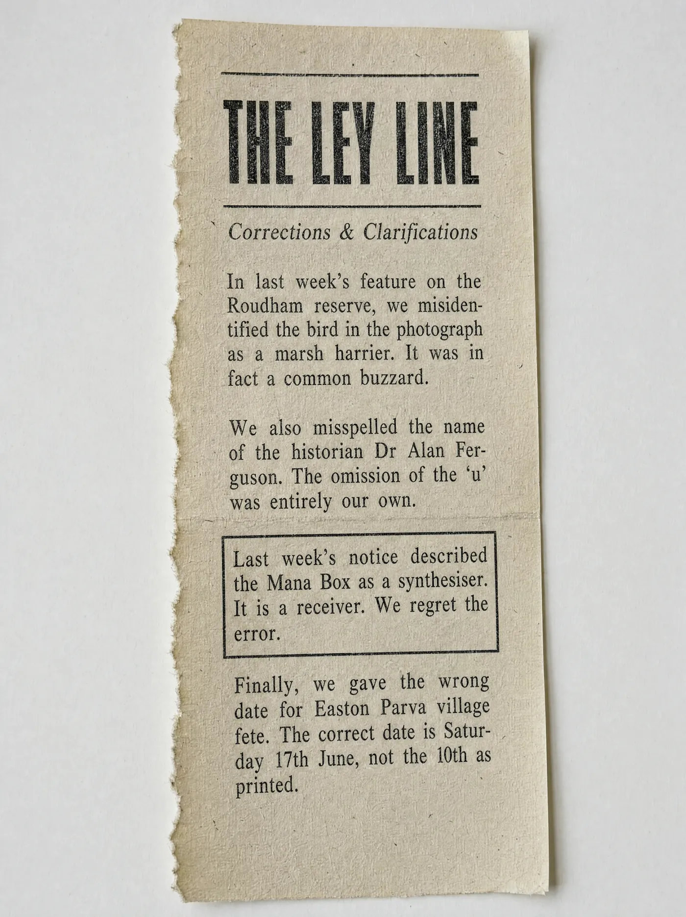 A torn column of newsprint from The Ley Line headed Corrections and Clarifications. Three ordinary corrections — a misidentified bird, a misspelt surname, the wrong date for a village fete — surround a fourth that has been ruled off in a box: last week's notice described the Mana Box as a synthesiser. It is a receiver. We regret the error.